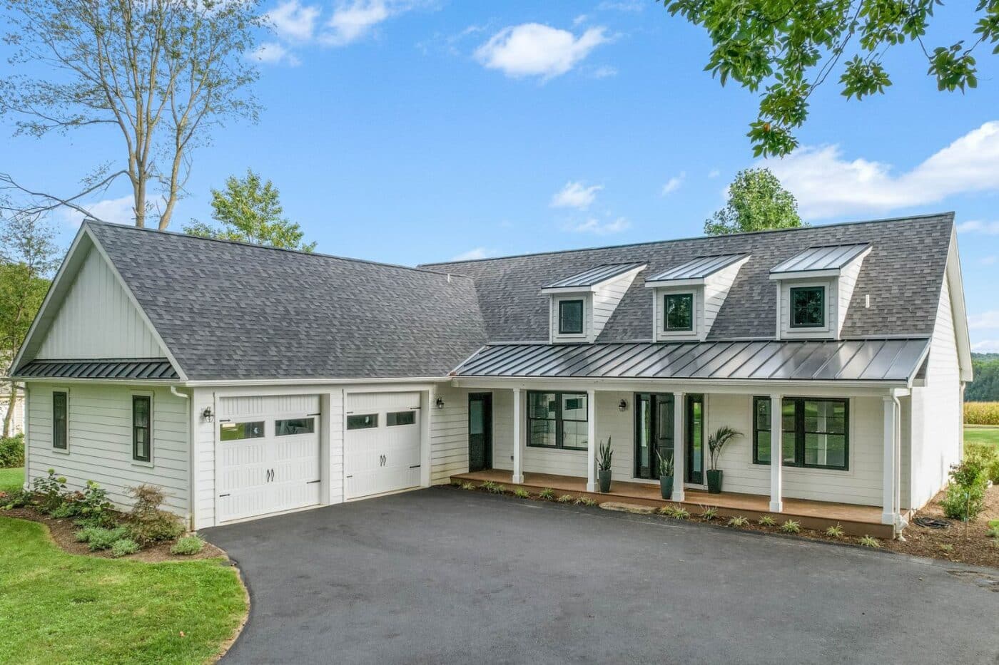 White modular cabin with garage set at location with surrounding garden and driveway