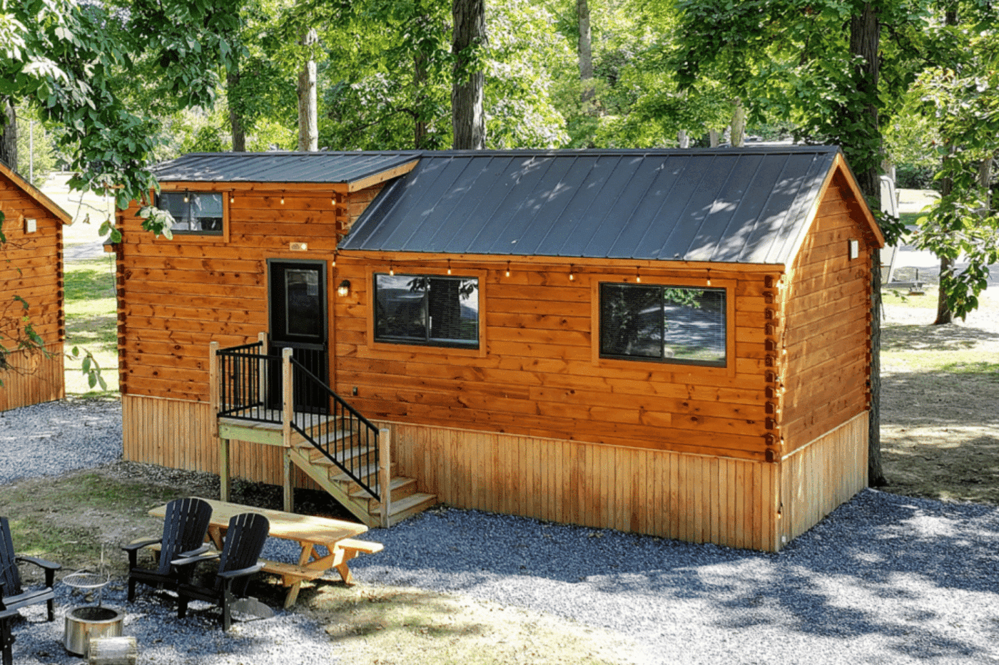 Exterior of Pinecrest Park Model cabin-style tiny home with wood siding and front steps leading to a small porch.