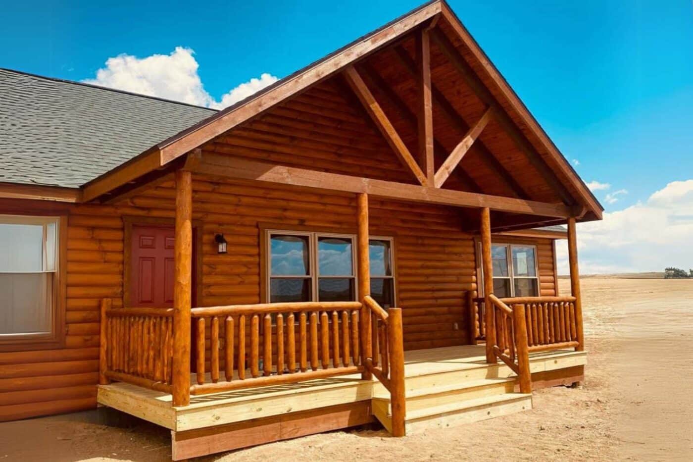 A-frame style log cabin in dessert on clear blue sky day