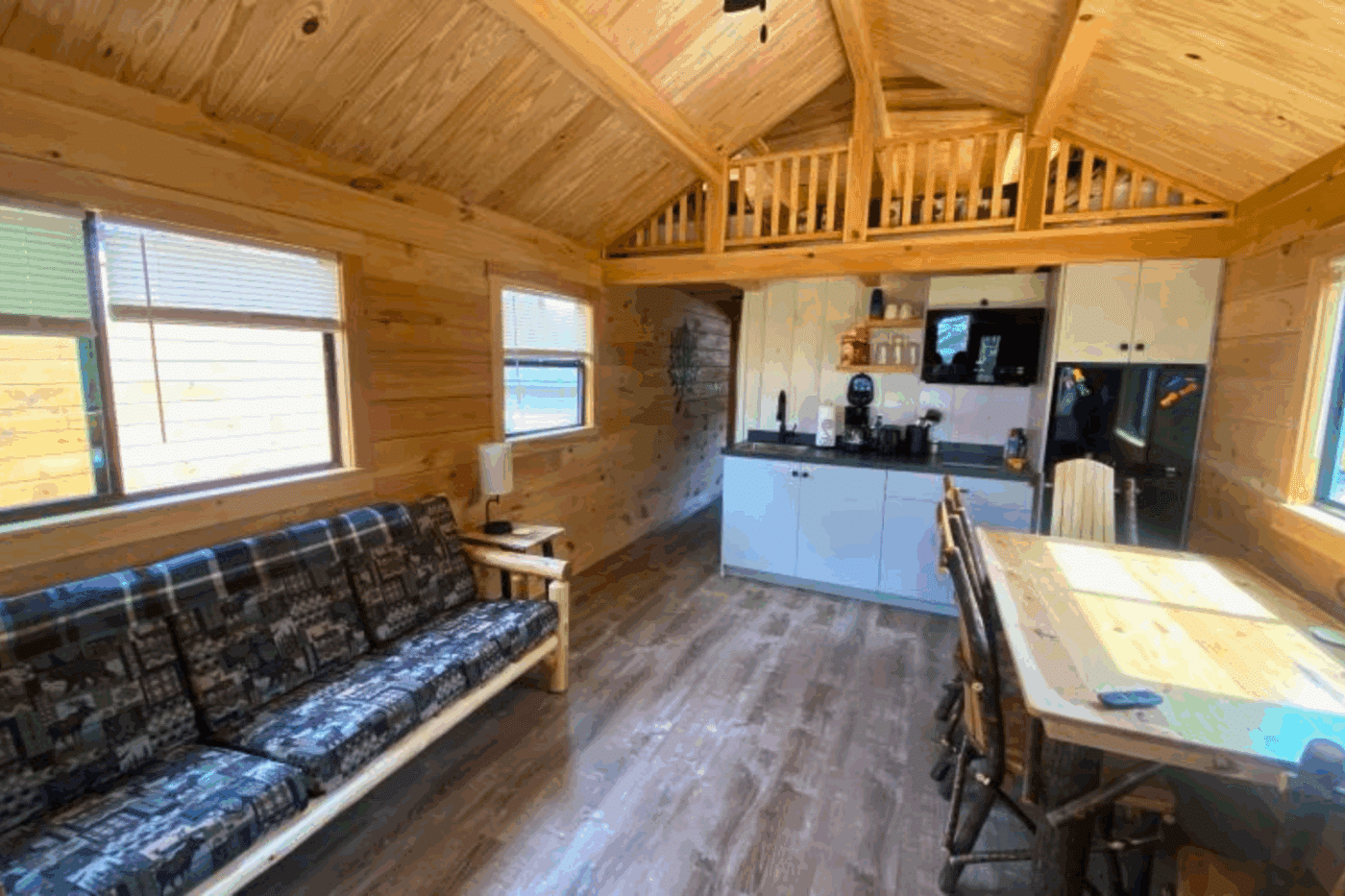 living room and lofted area of Aspen 3 park model log tiny home in houghton michigan