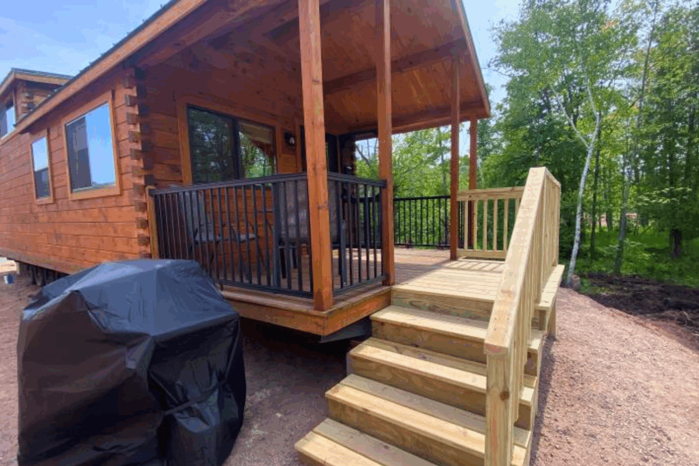 Aspen 3 park model log tiny home in Houghton Michigan at Keweenaw Water Resort with front porch