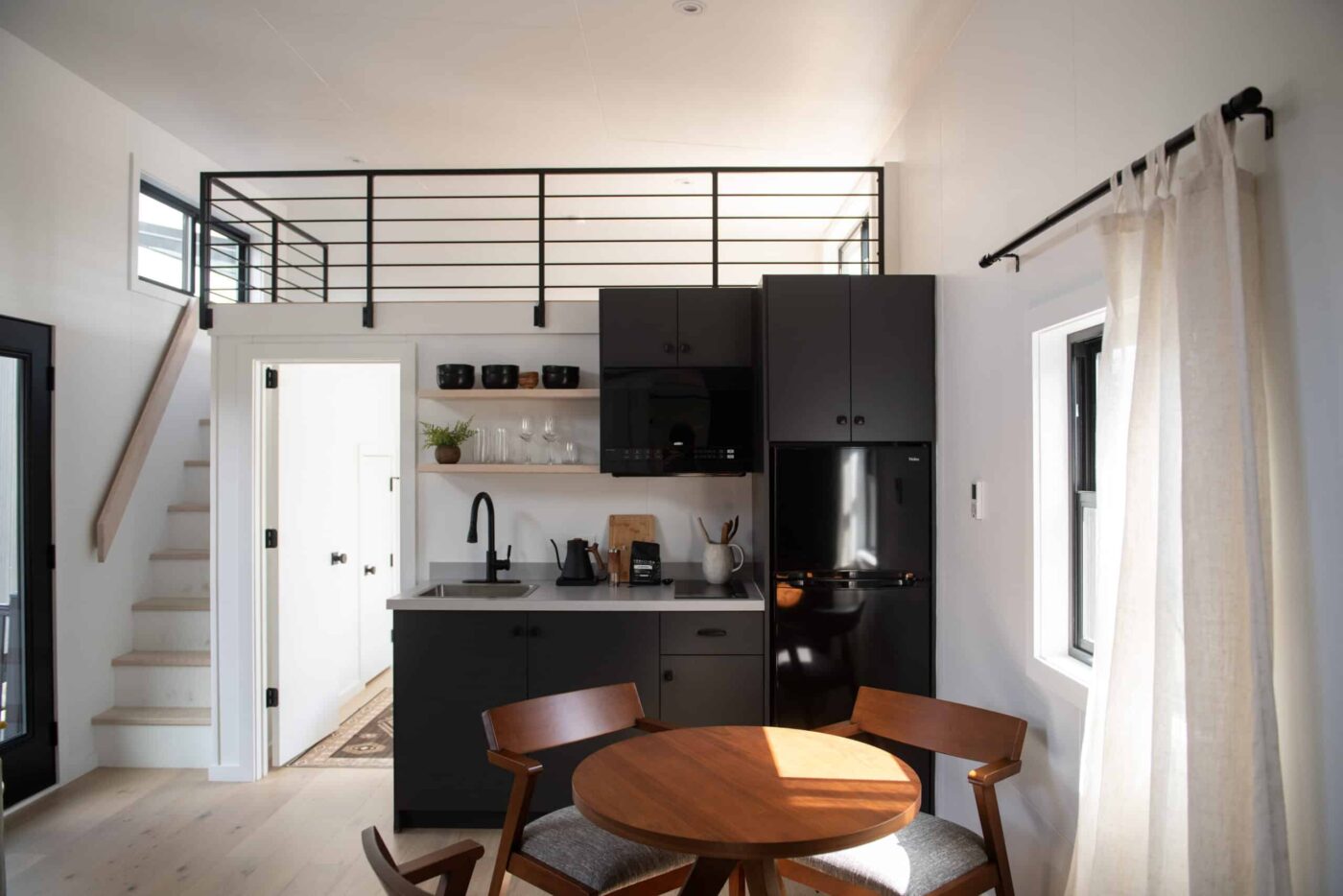 Cascade park model interior with loft, modern kitchen, and dining area.