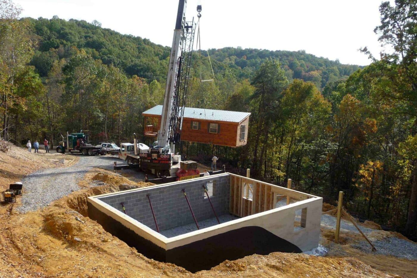 Log Cabin basement foundation prepped and ready for placement. Crane with cabin