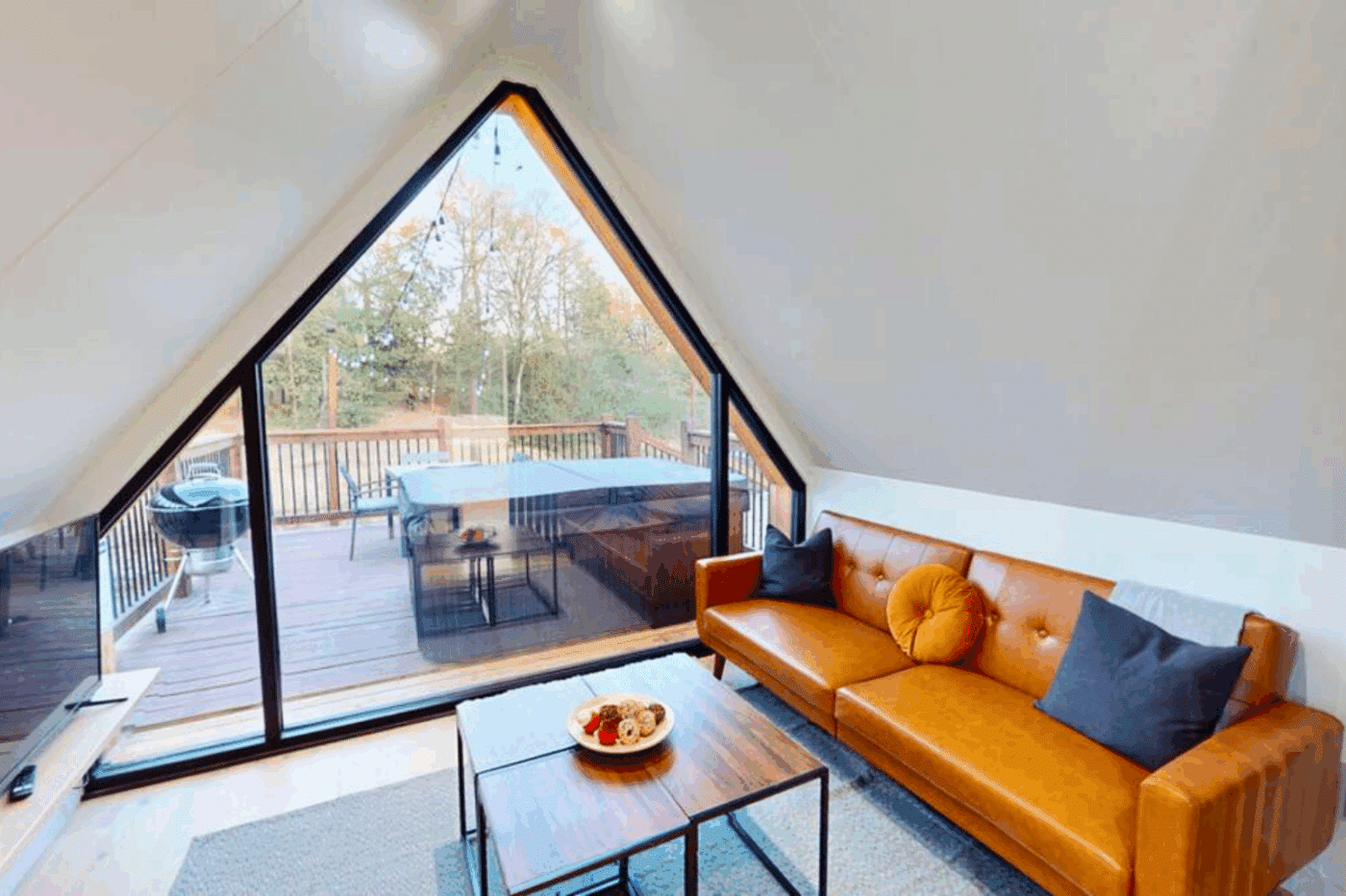 living room A frame park model tiny home with leather couch in Broken bow ok