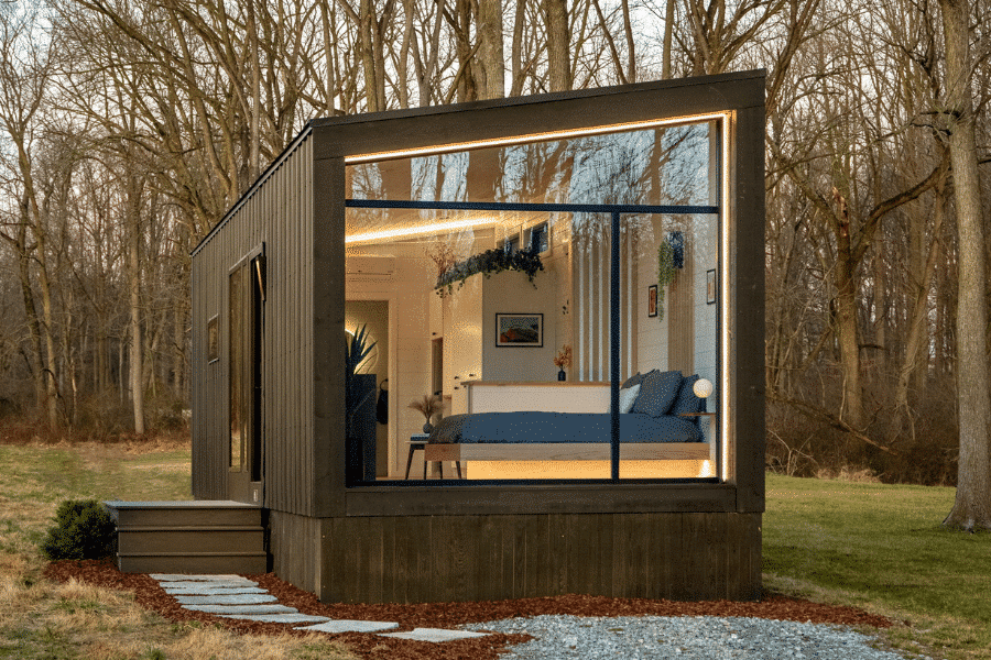 luna park model tiny home on gravel pad with open window showing bed