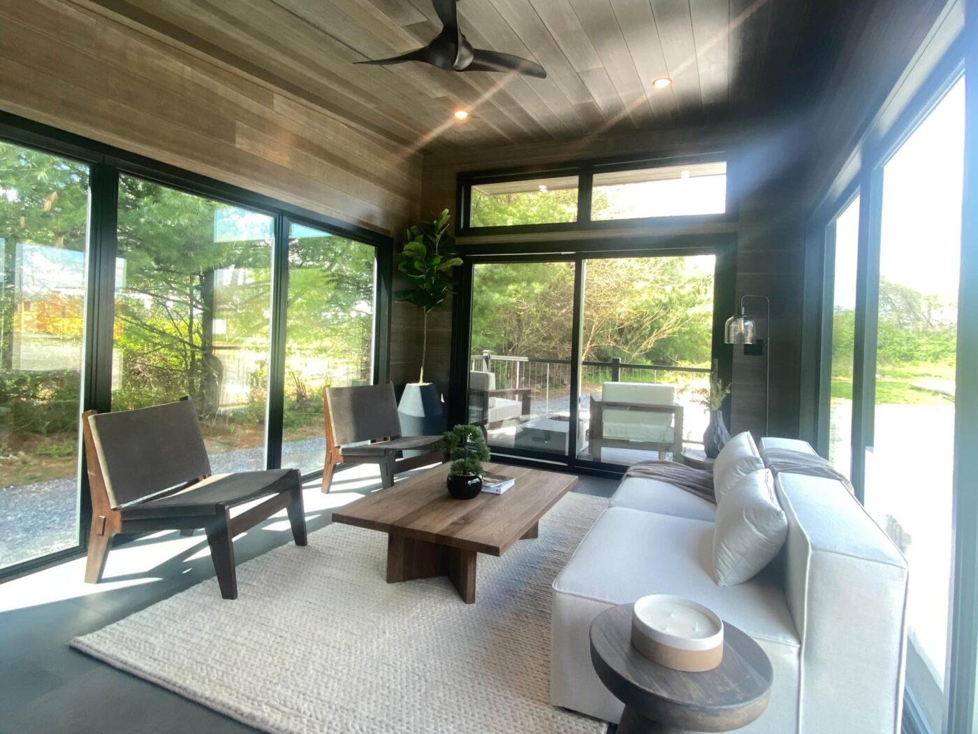 Bright living room in a luxury park model with floor-to-ceiling windows and modern furniture.