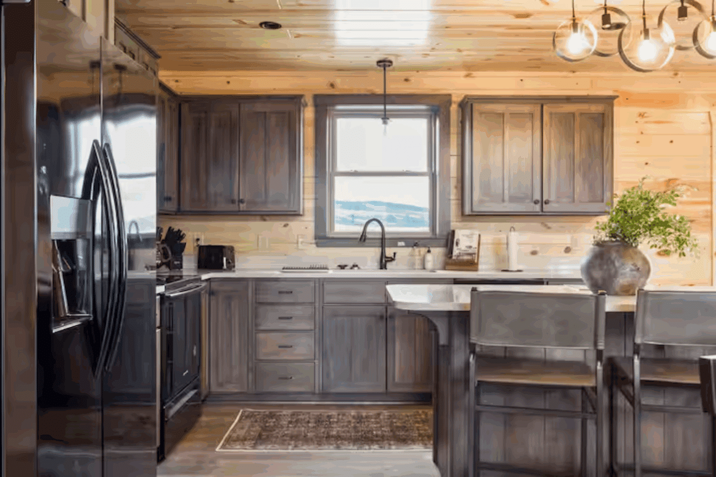 l shape kitchen counter with black appliances in canyon lodge log cabin in Driggs Idaho
