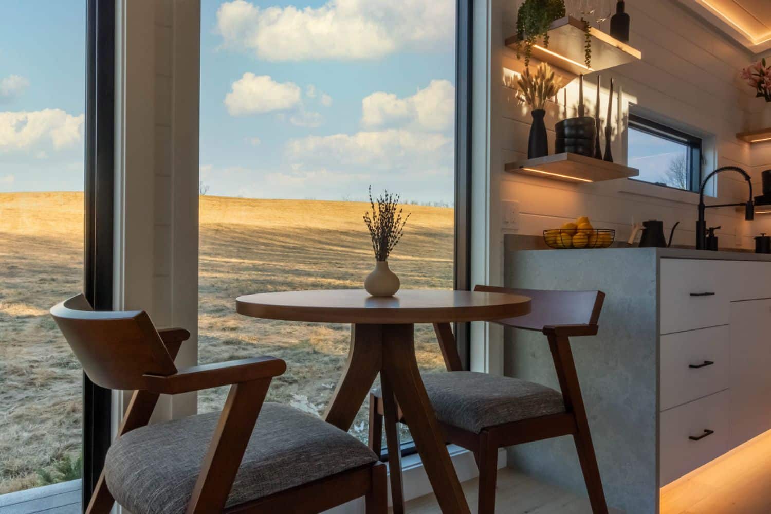 Table in tiny kitchen next to window looking out at blue sky