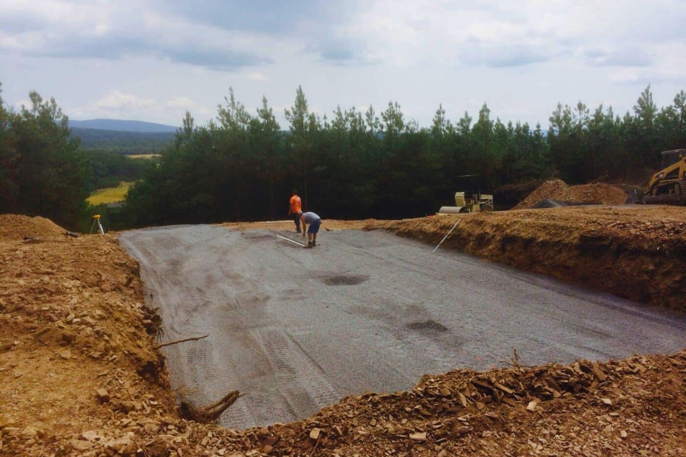 Gravel foundation spot with two workers leveling spot for log cabin