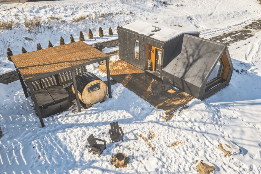 aerial view of black a frame ADU with covered hot tub beside it