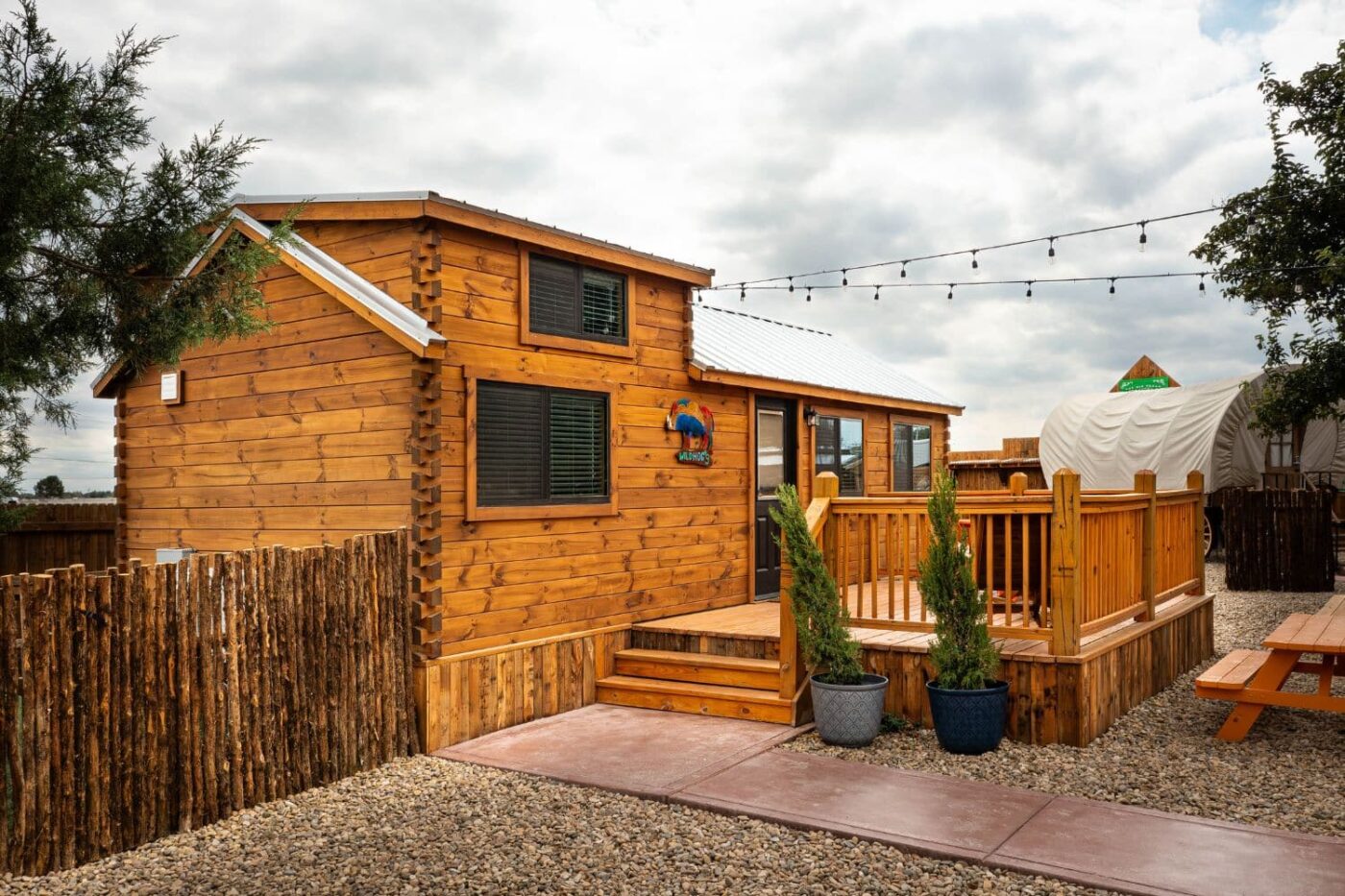 view of back deck attached to log cabin style park model on permanent foundation