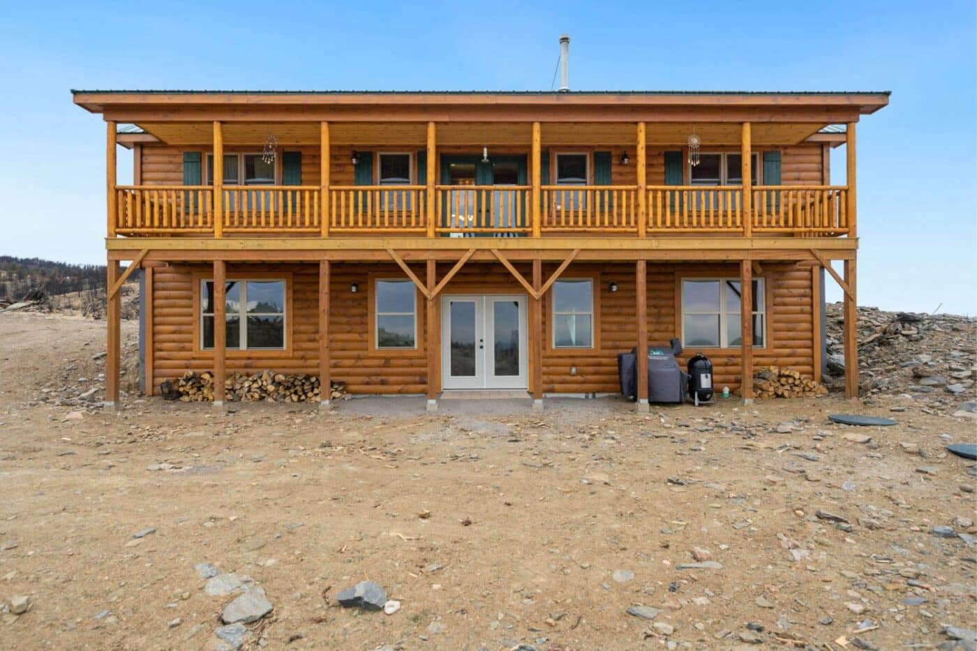 Two story log cabin on a concrete foundation in the desert